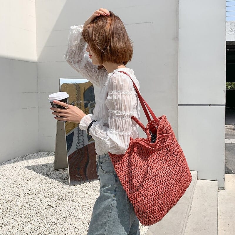 grand sac fourre tout tissé rose porté au bras