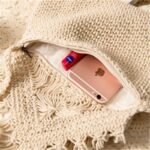 sac bandouiliere tissé à franges entre ouvert avec un iphone rose qui dépasse